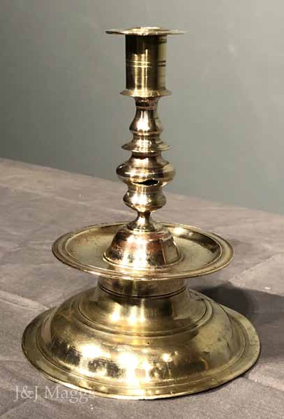 Lot - CONTINENTAL BRASS PRICKET STICK AND A CANDLESTICK, ON CAPSTAN TYPE  BASES